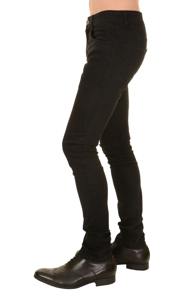 Model is stood in front of a white studio background wearing the black stretch denim skinny fit jeans with black brogues. They are stood facing towards the left and photo is cropped from the waist down.
