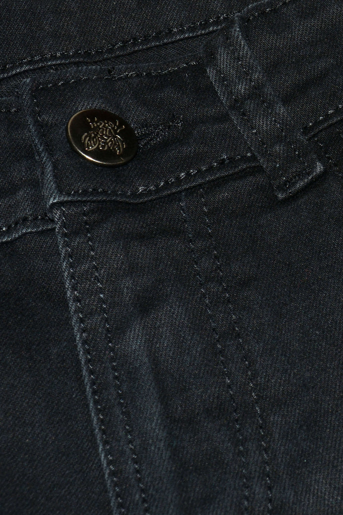 Close up shot of the black stretch denim skinny fit jeans' silver bee button close.