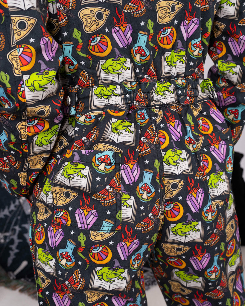 Back view of the Halloween: Bewitched Boiler Suit by Run & Fly, highlighting the vivid pattern featuring frogs, moths, and other magical motifs. Ethical slow fashion for those who love spooky vibes.