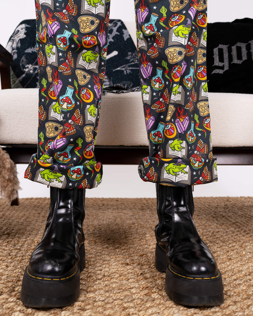 Model’s boots and rolled cuffs of the Halloween: Bewitched Boiler Suit by Run & Fly. The eye-catching print pops with colourful designs of magical creatures and symbols, embodying the brand’s ethical slow fashion values.