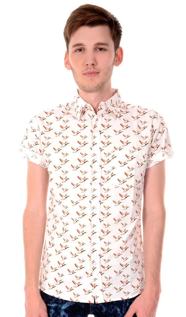 White flying ducks short sleeve shirt with orange ducks printed, retro style button up shirt with neck collar being modelled by a guy with brown hair smiling looking to camera.