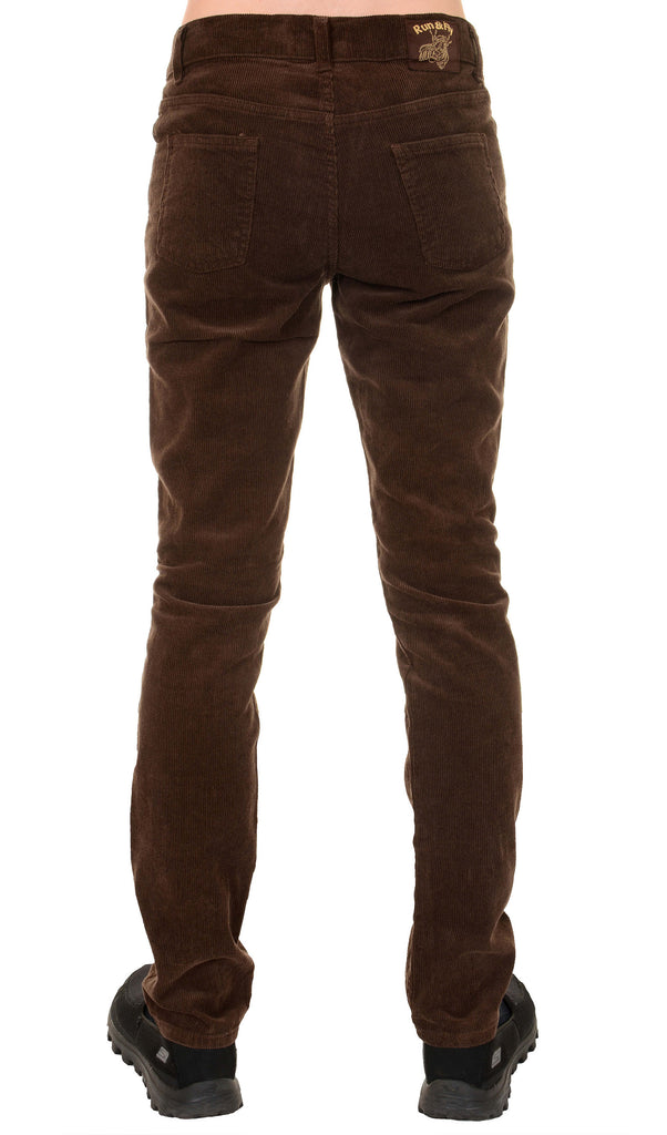 Model is stood in front of a white studio background wearing the mens 60s brown corduroy slim fit jeans with black trainers. They are facing away from the camera. Photo is cropped from the waist down.