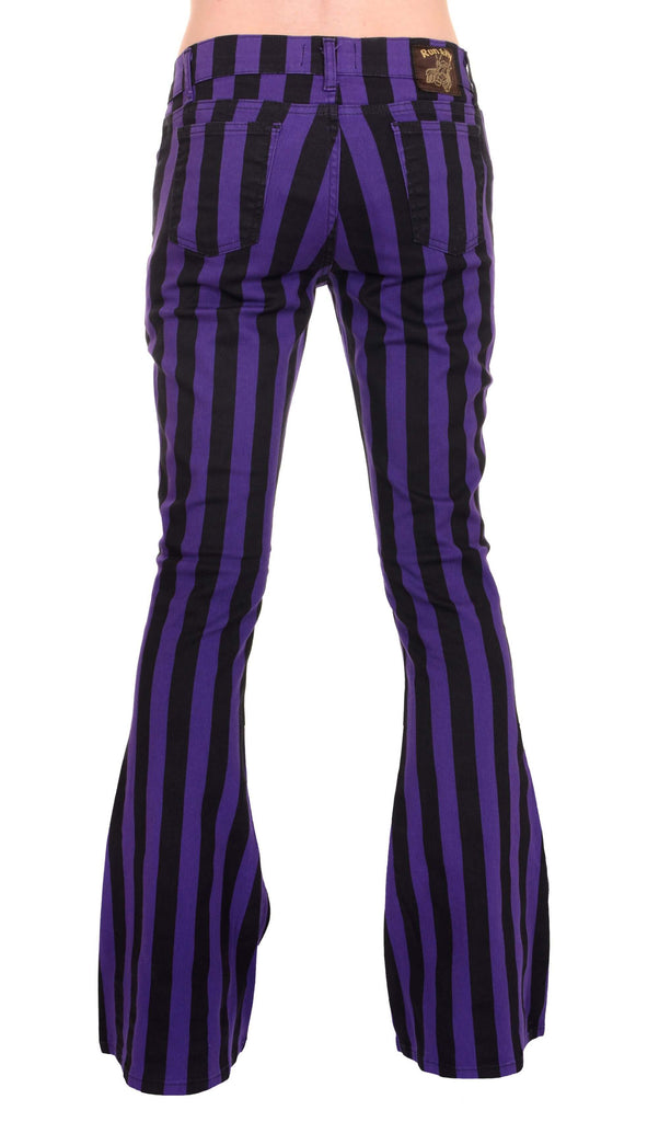 Model is stood in front of a white studio background wearing the purple and black striped bell bottom stretch super flares with grey trainers. They are facing away from the camera and photo is cropped from the waist down.