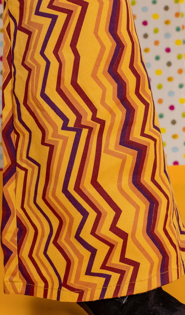 Close up shot of the zig zag print bell bottom stretch super flares over black boots.