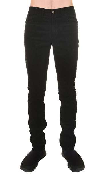 Model is stood in front of a white studio background wearing the mens 60s black corduroy slim fit jeans with black trainers. They are facing towards the camera. Photo is cropped from the waist down.