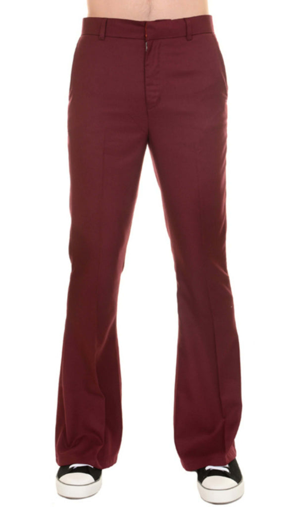 Model is stood in front of a white studio background wearing the Presley burgundy bell bottom trouser slacks with black trainers. They are facing forward and photo is cropped from the waist down.