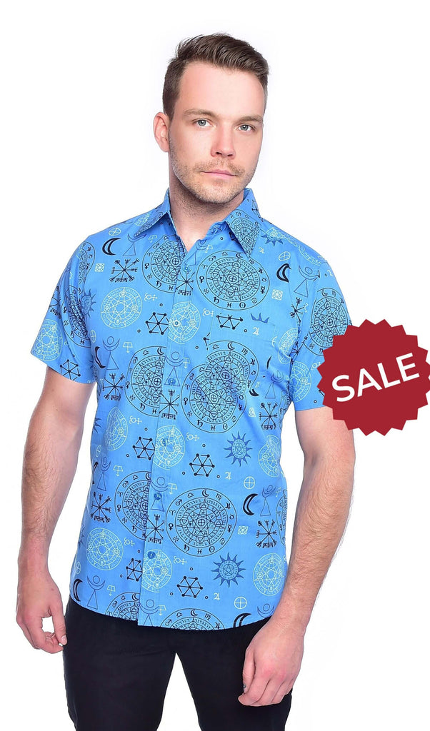 Model is stood in front of a white studio background wearing the supernatural magic symbol print shirt with black trousers. They are facing forward posing with both arms resting by their sides. Photo is cropped from the hips up.