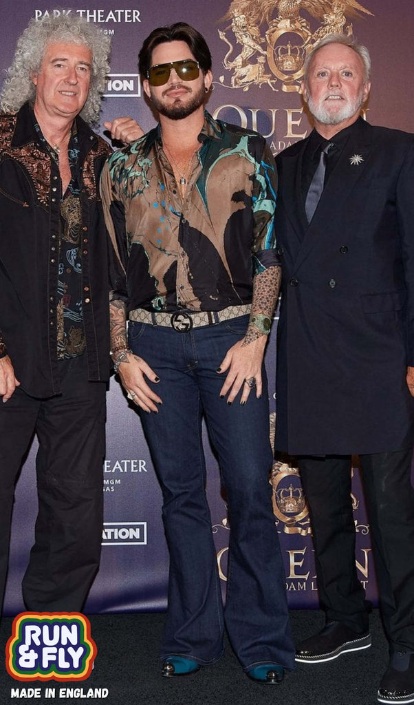 Celebrity photo of queen and Adam Lambert wearing the indigo blue bell bottom super flares. with a multicoloured shirt and blue boots.