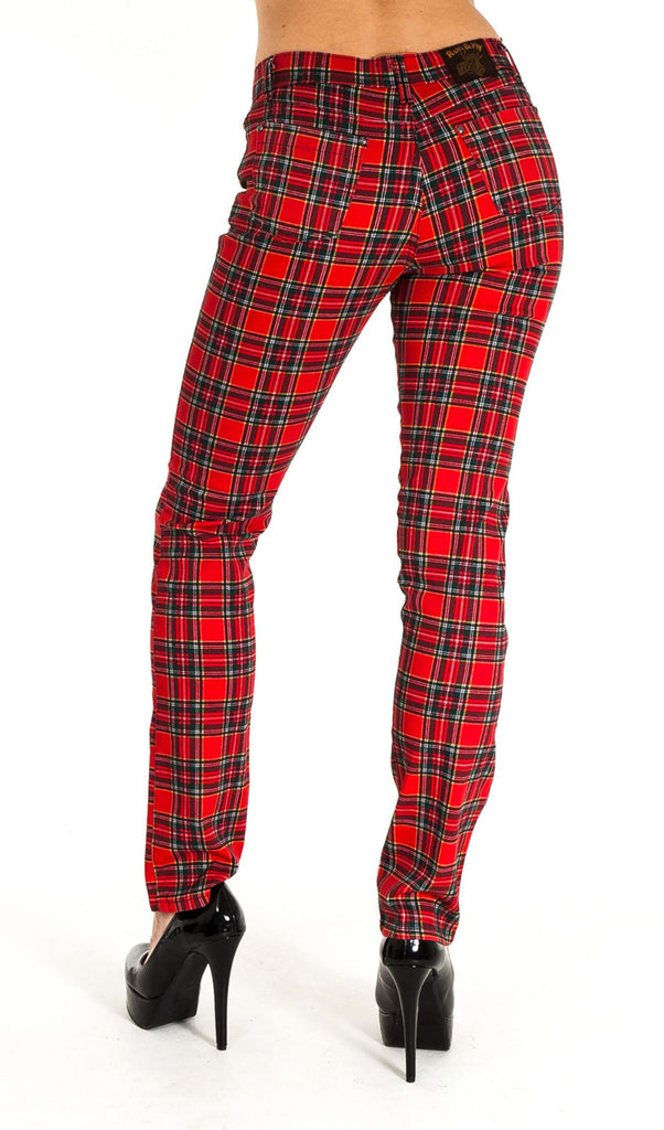 Model is stood in front of a white studio background wearing the mid rise red tartan stretch skinny jeans with black heels. They are facing away from the camera. Photo is cropped from the waist down.