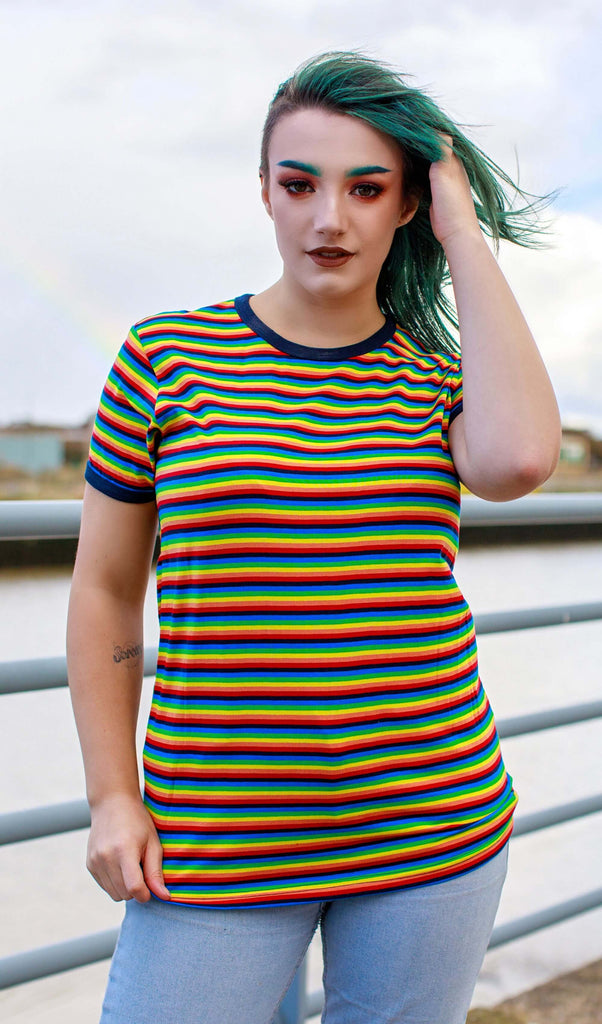 Kat with bright green hair and matching eyebrows wearing the Retro Rainbow Brights Repeat Striped T Shirt and light blue jeans