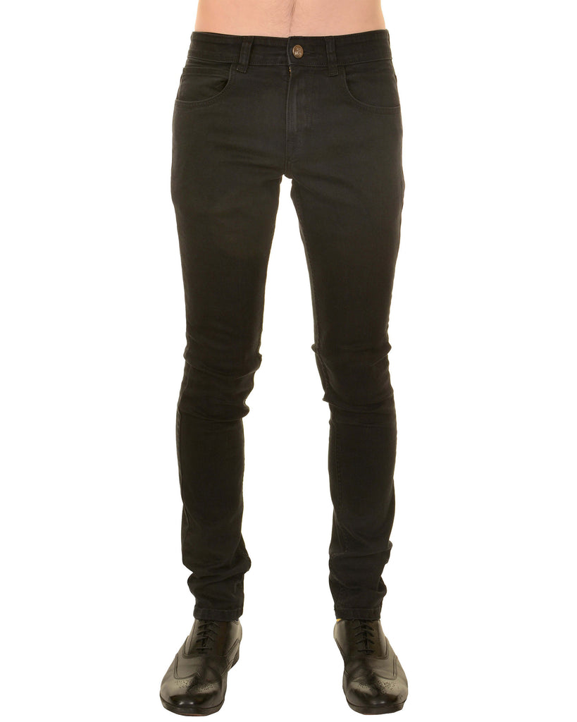 Model is stood in front of a white studio background wearing the mens 60s black corduroy slim fit jeans with black trainers. They are facing towards the camera. Photo is cropped from the waist down.