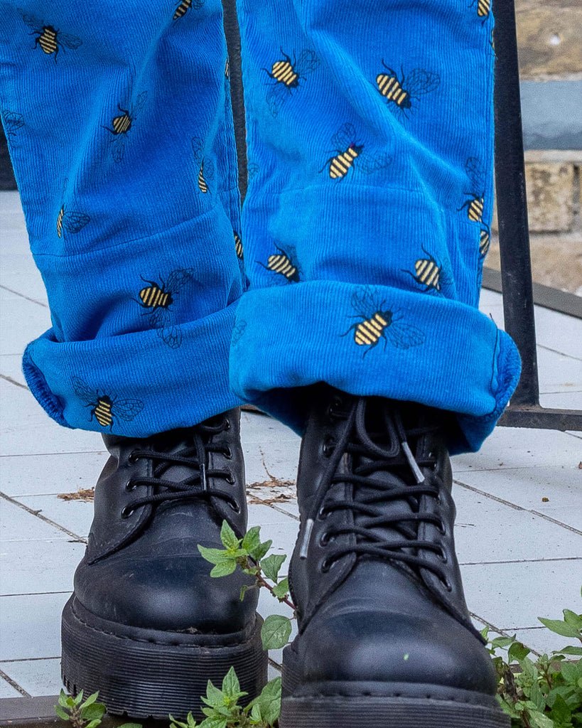 close up of blue corduroy dungarees rolled up at the ankle with Doc Marten boots underneath shot outside in Hove