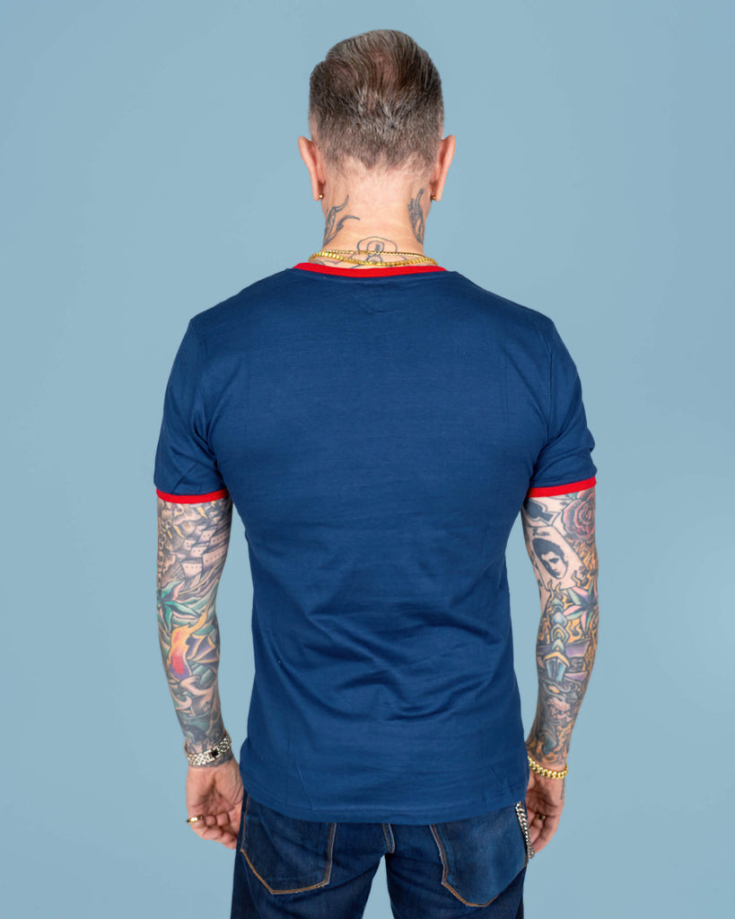 Back view of the navy t-shirt worn by James, highlighting the simple yet stylish design. The red trim on the sleeves and neckline continues to stand out, paired with the shirt’s comfortable fit.