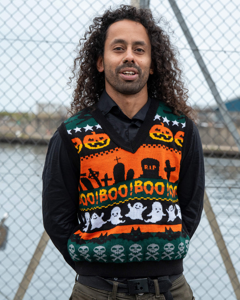 Model Rich smiles wearing the Run & Fly BOO! Tank Vest with colourful Halloween motifs of ghosts, skulls, and pumpkins.