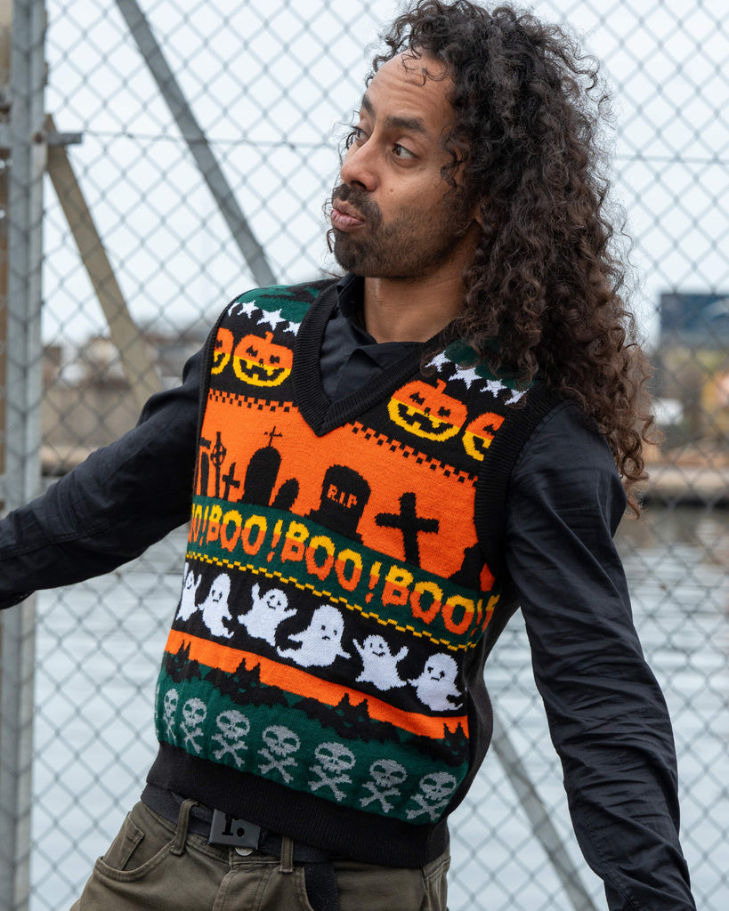 Model Rich poses playfully in the Run & Fly BOO! Tank Vest featuring an orange and black spooky knit with ghosts and “BOO!” text.