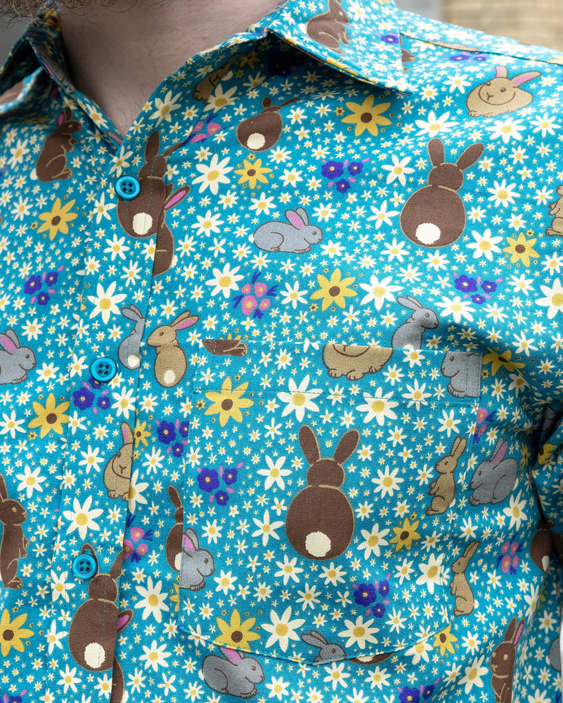 Closeup of cute Bunny Meadow short sleeve blue shirt with floral daisy print
