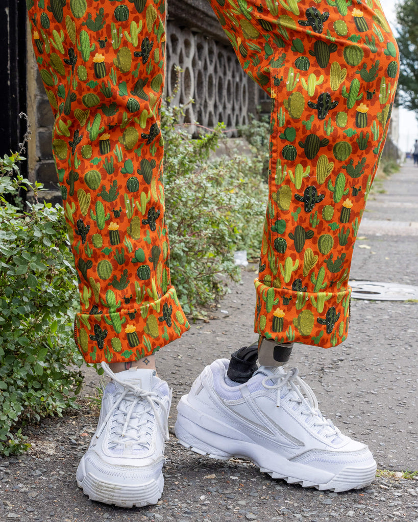 close up of Cactus Stretch Twill Dungarees. Close up shows the upturned legs of the dungarees with white trainers underneath. The photo is taken outdoors in Hove.