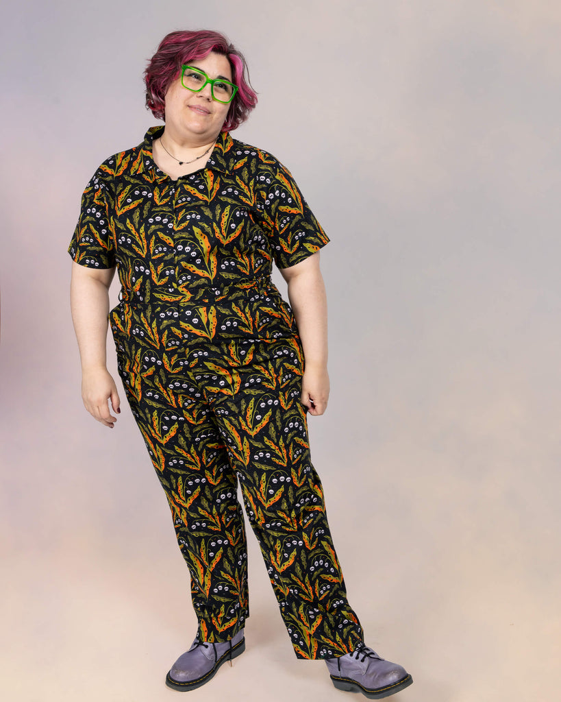 Full-body shot of Jackie Brand in a Run & Fly jumpsuit with a whimsical botanical skull print by Clare Lewis. The relaxed fit and playful style are highlighted.