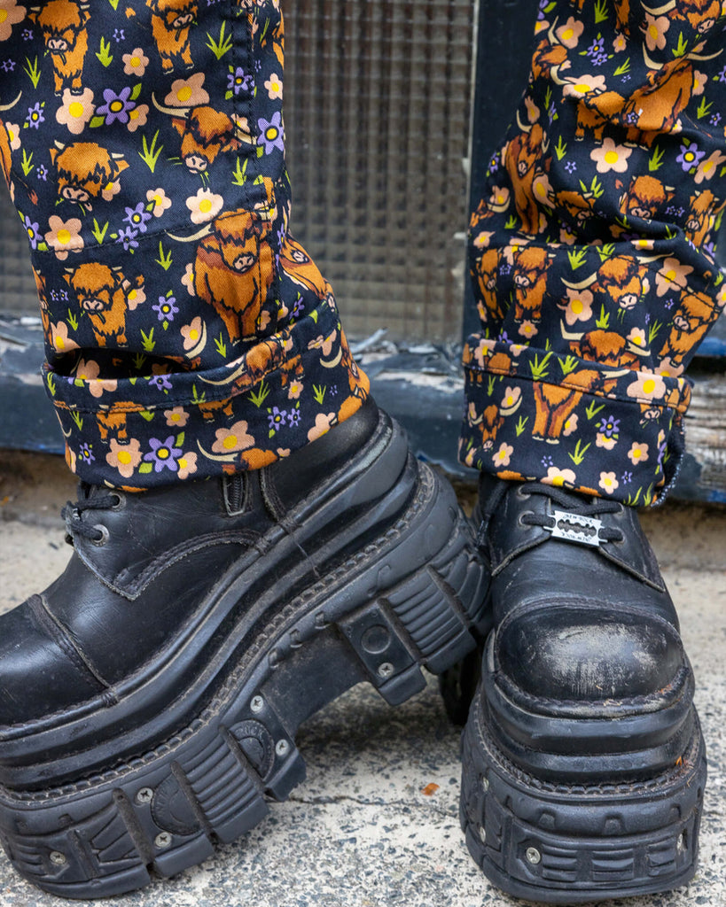Matching turn ups on the Highland Cows Stretch Twill Dungarees with black boots underneath.