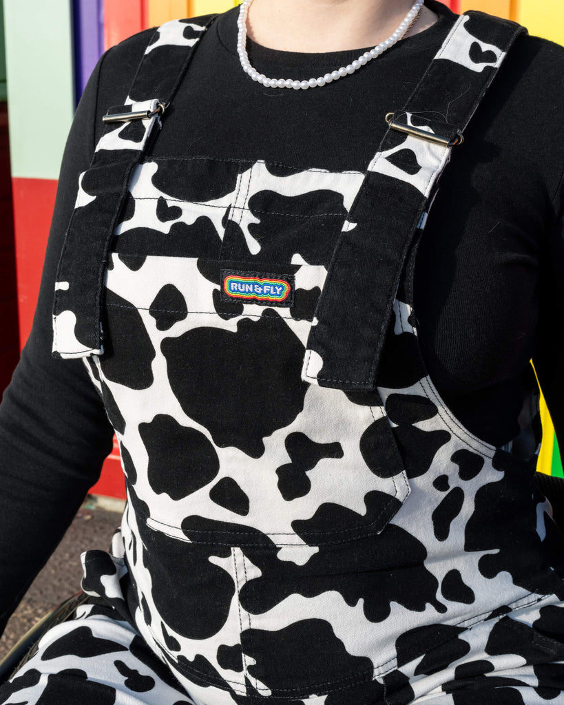 Close-up of the front pocket detail on the Run & Fly Cow Print Stretch Twill Dungarees. The black and white cow print design offers a bold, fun look from this small ethical slow fashion brand, perfect for making a statement.
