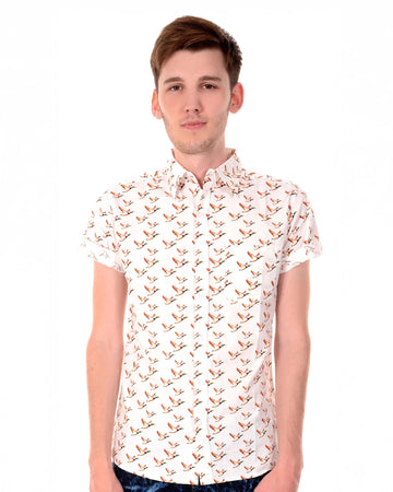 White flying ducks short sleeve shirt with orange ducks printed, retro style button up shirt with neck collar being modelled by a guy with brown hair smiling looking to camera.
