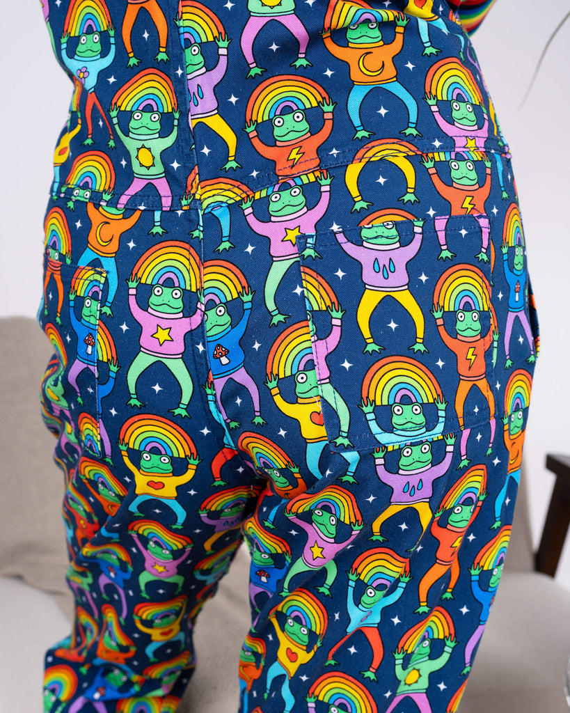 Close-up of the back pocket of Run & Fly Rainbow Frogs Stretch Twill Dungarees, featuring vibrant cartoon frogs with rainbow halos on a navy background. Ethically made slow fashion with bold, playful design.