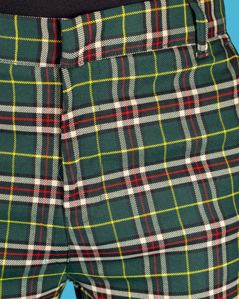 Close up photo of the green tartan plaid bell bottom slacks zip fly close.