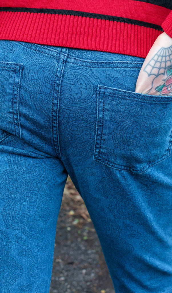 Close up shot of the back pocket on the retro stretch stone wash denim Hendrix paisley bell bottom flares with the models hand in.