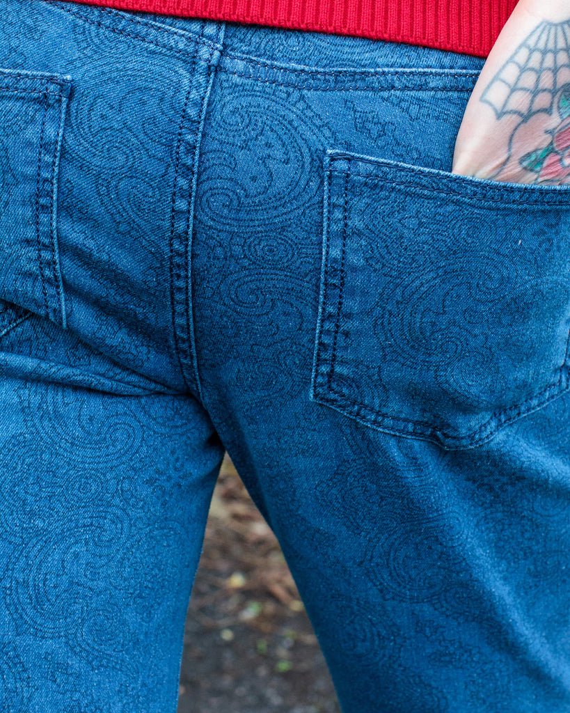 Close up shot of the back pocket on the retro stretch stone wash denim Hendrix paisley bell bottom flares with the models hand in.