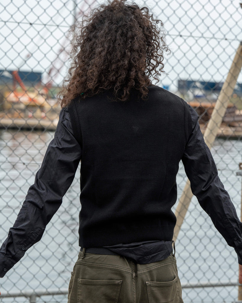 Back view of the Run & Fly Highland Cow Tank Vest showing the plain black back design. Model Rich wears it layered over a black shirt for a smart, casual outfit.
