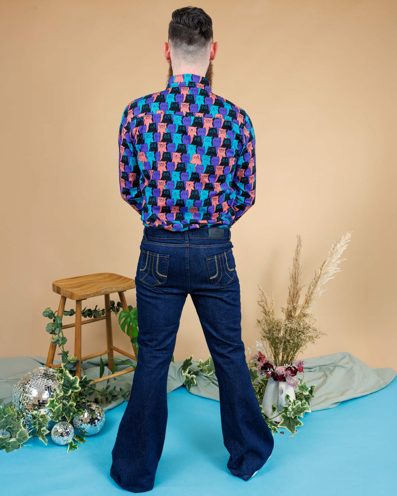 male model wearing Indigo Blue Mid-Low Rise Bell Bottom Super Flare paired with Cat Chorus Print Long Sleeve Shirt. He is stood in a studio in Hove with his back facing the camera.