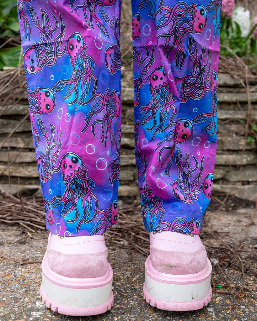 Back view of the Run & Fly Jellyfish Stretch Jumpsuit trousers, with a focus on the wide-leg fit and playful pink jellyfish pattern, styled with pastel pink platform shoes.