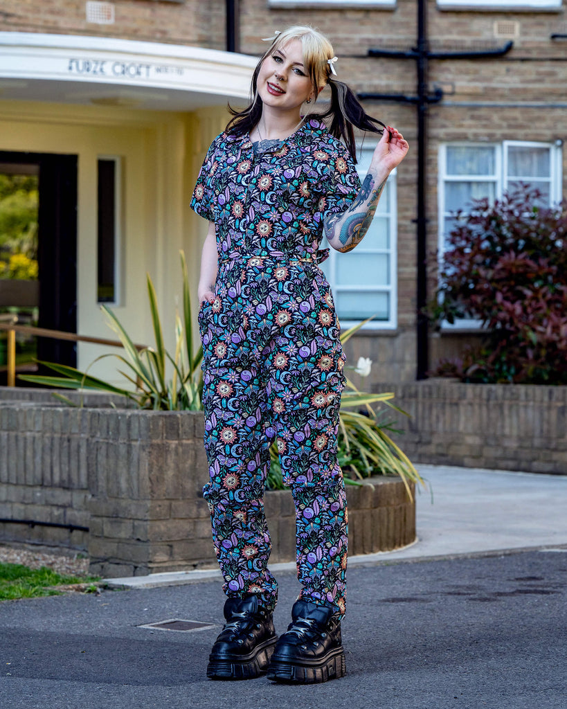 Full front view of the Boho Summer Stretch Jumpsuit by Run & Fly, worn outdoors. Features playful cosmic illustrations and a flattering fitted shape. Made with vegan dyes.