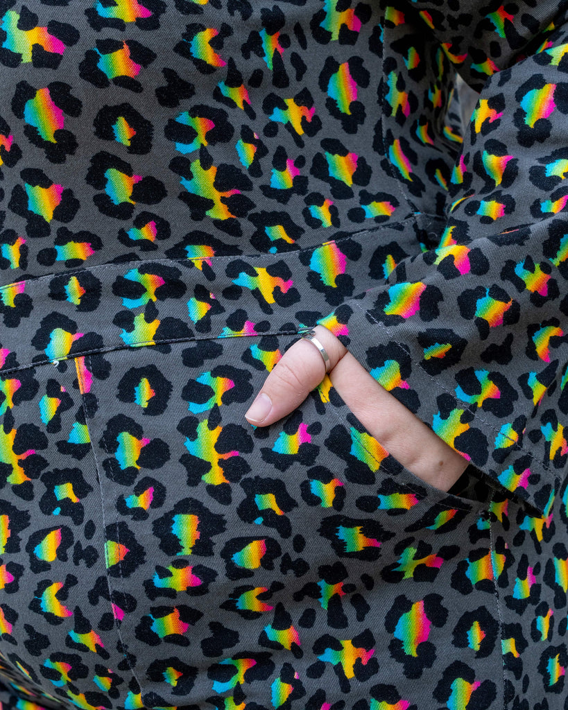 Close-up of the pocket detail on the Rainbow Leopard Stretch Twill Boiler Suit by Run & Fly. The colourful leopard print pops against the black background, with the model’s hand in the pocket emphasising the functional design. A playful and bold piece from an ethical slow fashion brand.