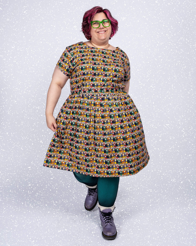 Jackie smiles brightly while posing in the Nutcracker tea dress by Waffle Mama for Run & Fly. The playful pattern of festive Nutcrackers and the flattering tea dress silhouette create a cheerful, wintery vibe.