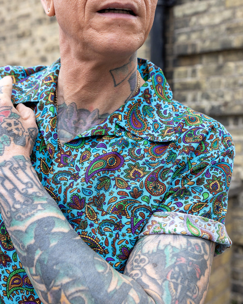 Close up James wearing Sky Blue Paisley Short Sleeve Rayon Shirt. HIs arm is resting on his chest.