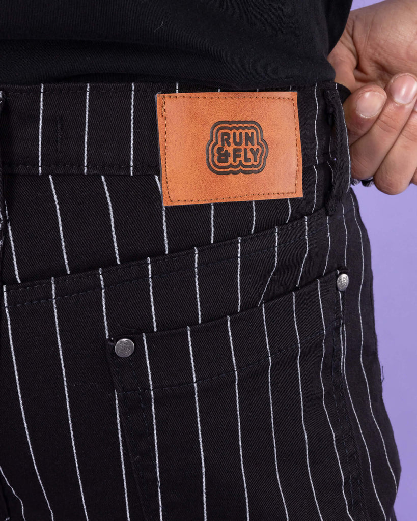 Close up of the back of the Stretch Black & White Pinstriped Skinny Jeans with Run & Fly logo on the label on the back.
