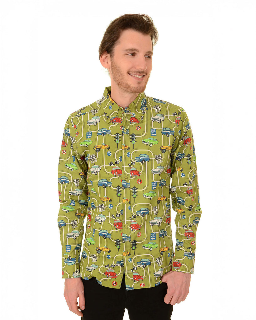 Model is stood in front of a white studio background wearing the race track car play button down long sleeve shirt with black trousers. They are facing forward posing with both arms resting by their side and looking to the right smiling. Photo is cropped from the knees up.