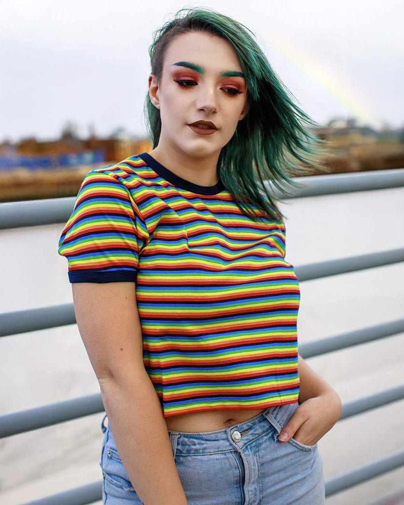 Kat is wearing the Rainbow Brights Repeat Striped Cropped T Shirt and has green coloured hair and matching eyebrows