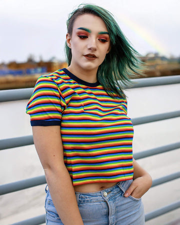 Kat is wearing the Rainbow Brights Repeat Striped Cropped T Shirt and has green coloured hair and matching eyebrows