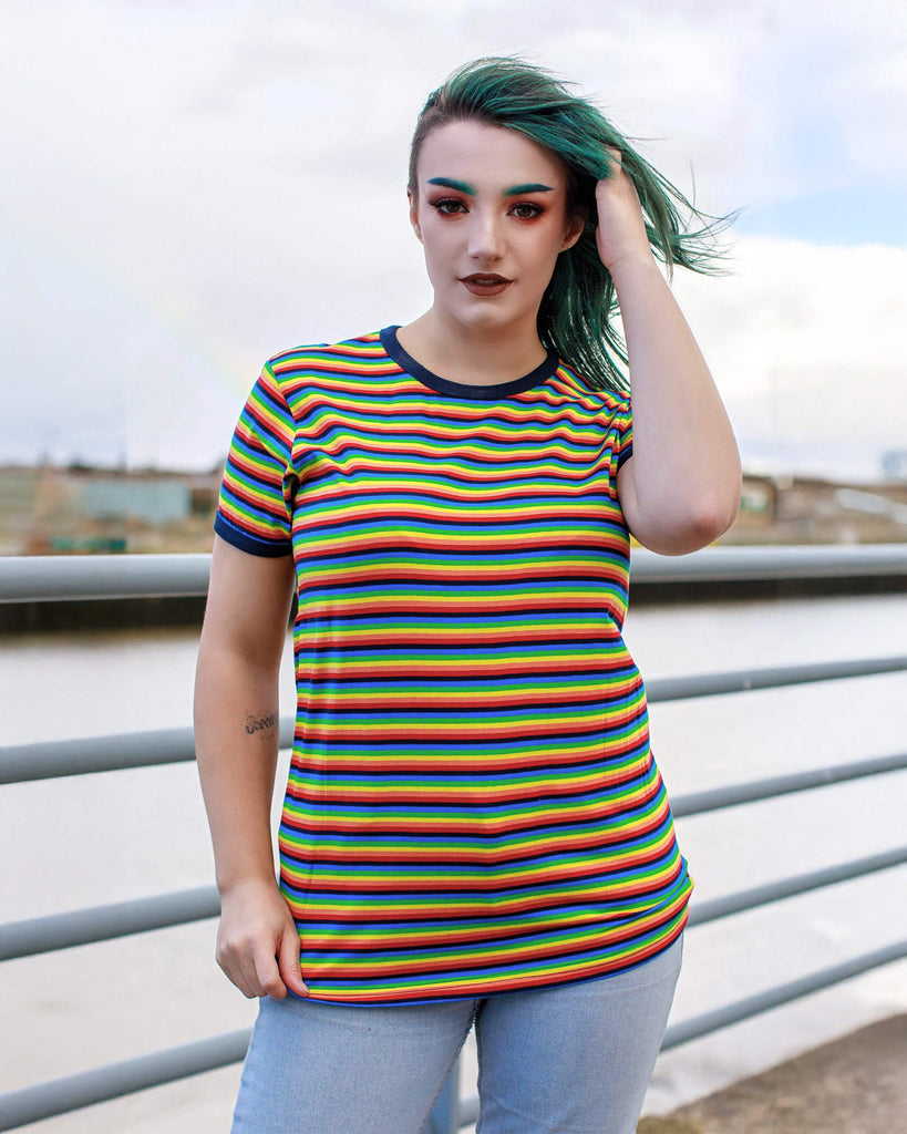 Kat with bright green hair and matching eyebrows wearing the Retro Rainbow Brights Repeat Striped T Shirt and light blue jeans