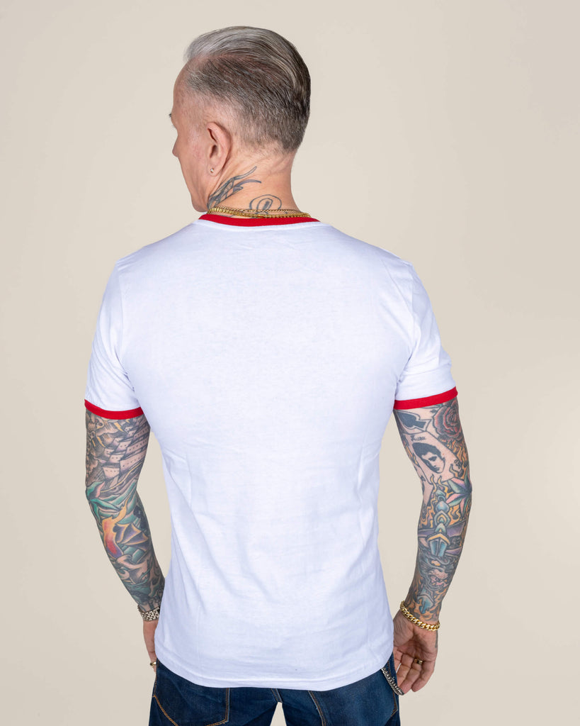  Back view of James modelling the white T-shirt, showcasing the simple back design and the flattering fit, while his tattooed arms and neck add a bold edge to the look.