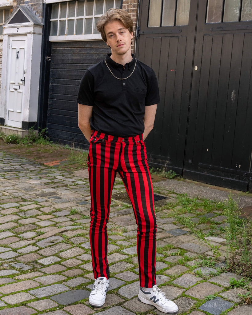 The model stands in front of a black garage door wearing Run & Fly’s red and black striped skinny jeans. Paired with a black polo and white trainers, the bold vertical stripes create a striking contrast. The casual yet stylish look captures the essence of Run & Fly’s ethical slow fashion ethos, blending vintage vibes with contemporary edge.