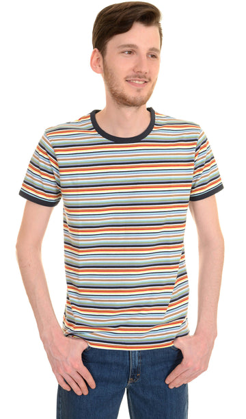 Model is stood in front of a white studio background wearing the retro multi striped ringer tshirt with denim jeans. They are facing forward with both hands in the front trouser pockets and looking off to the right smiling. Photo is cropped from the hips up.