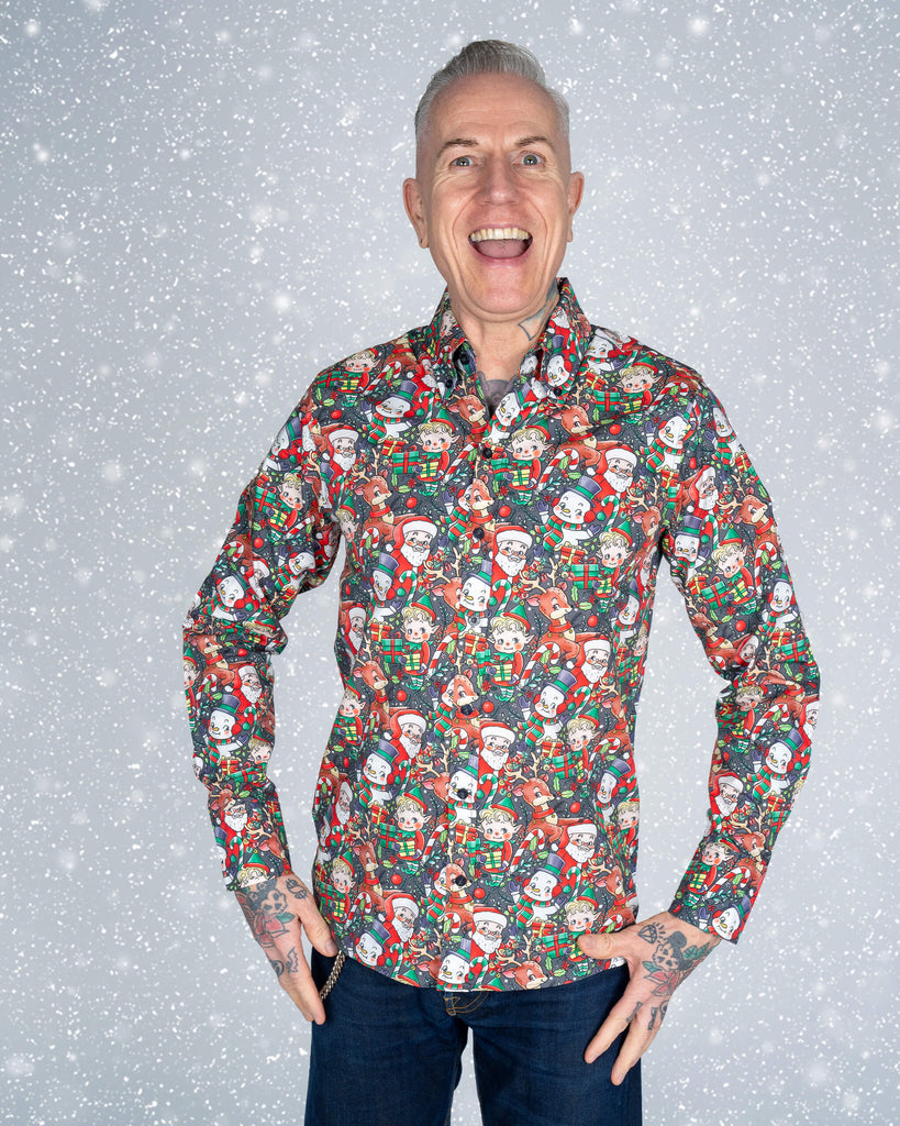 A model smiles brightly while wearing a bold Christmas print shirt by Run & Fly. The shirt features retro-style designs of Santa, elves, snowmen, and reindeer with vibrant festive colours. A playful and ethical addition to any seasonal wardrobe, designed by this small slow fashion company.