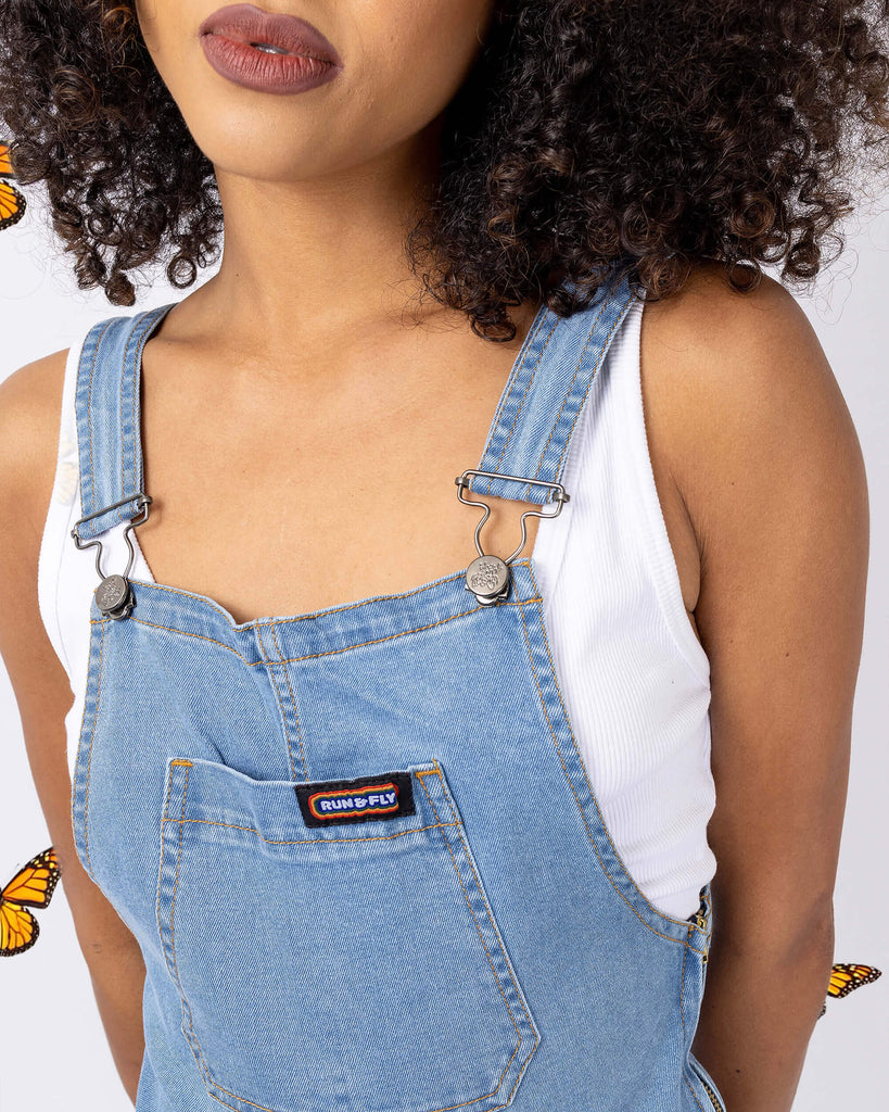 Close up front photo of Cindy wearing the light blue denim stretch skinny flared dungarees with a white short sleeved tshirt underneath.
