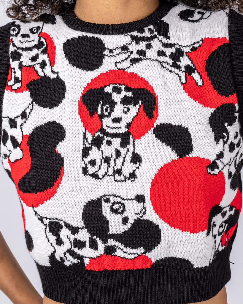 Cindy is stood in front of a white studio background wearing the seeing spots Dalmatian knitted tank top with leather look leggings. They are facing forward with both hands on their hips. Photo is cropped from the chin to hips.