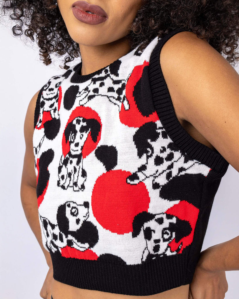 Cindy is stood in front of a white studio background wearing the seeing spots Dalmatian knitted tank top with leather look leggings. They are facing forward with both hands on their hips. Photo is cropped from the chin to hips.