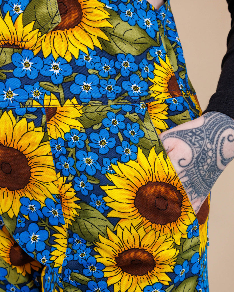 close up of model's hand in the pocket of Run & Fly x Jen James Design Forget Me Not Charity Stretch Twill Dungarees