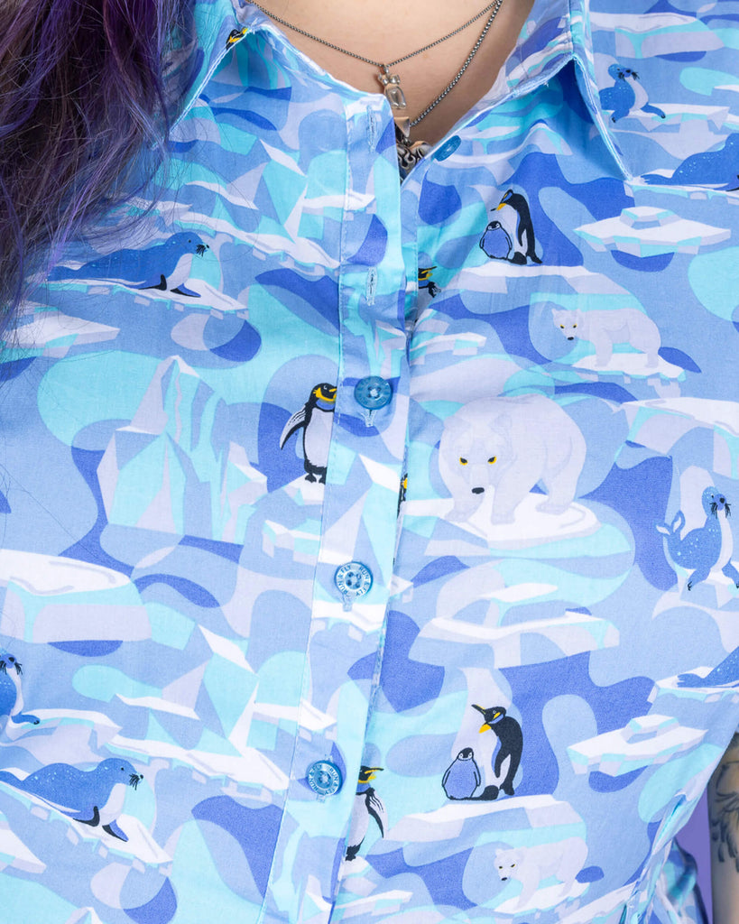 close up of model with wearing Winter Friends Stretch Jumpsuits. The jumpsuit is a light blue colour with ice burgs, seals, polar bears and penguins on. The close up shows the beautiful design in more detail and the blue buttons on the front of the jumpsuit,